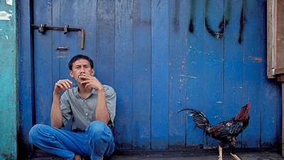 An Indonesian man smokes a cigarette.